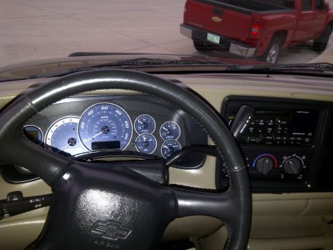 2002 Chevrolet Silverado 1500 - View from inside a 2002 Chevrolet Silverado 1500, showing the dashboard and steering wheel, with another red truck in the background.