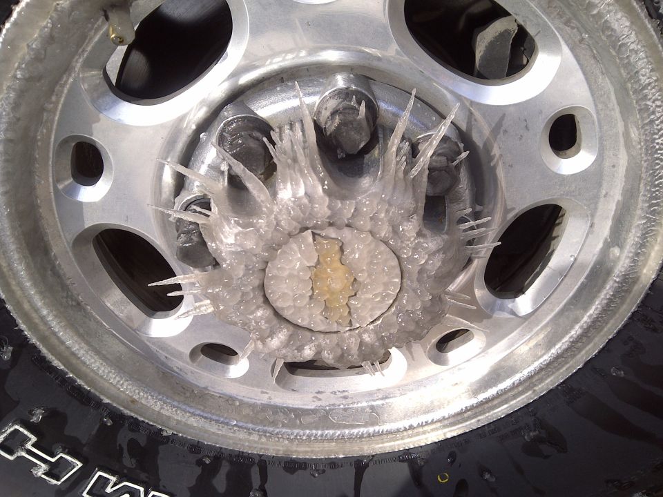 Ice and sideways icicles frozen on an aluminum 6-lug wheel and lug nuts