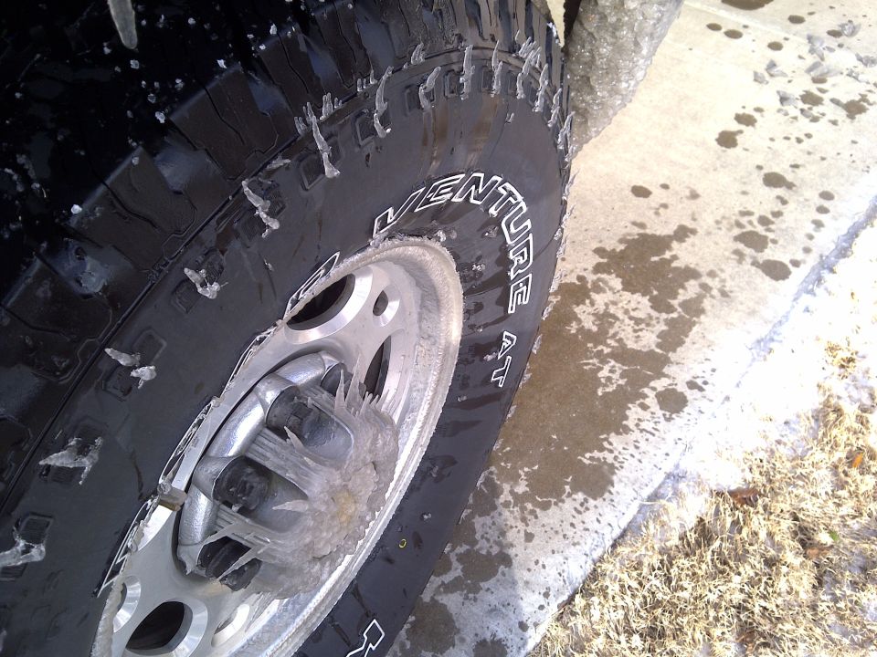 Close-up of a tire with ice on it, showing the 'VENTURE AT' text