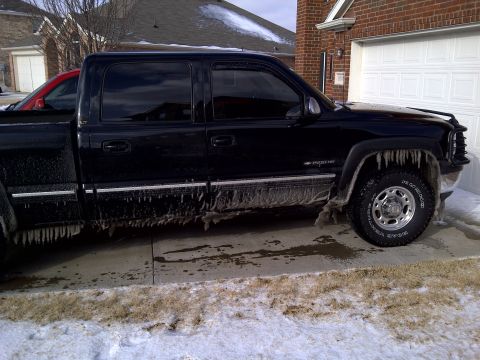 2002 Chevrolet Silverado 1500 - Side view of a black 2002 Chevrolet Silverado 1500 pickup truck with ice accumulation.