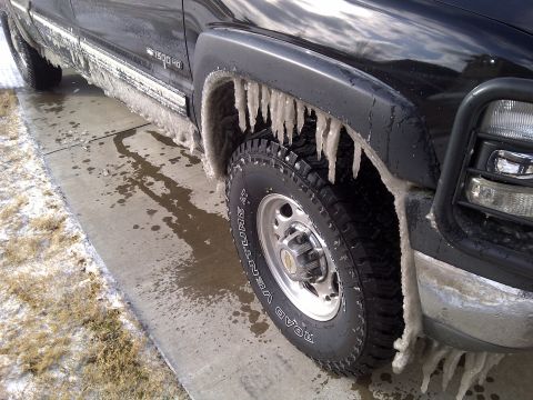 2002 Chevrolet Silverado 1500 - This black pickup truck is covered in ice and icicles after a cold weather event.