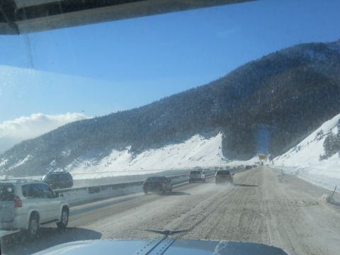 2009 Kenworth T800 - Driving through a snowy mountain pass with multiple vehicles on the road.