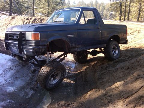 1988 Ford Bronco - This modified Ford Bronco navigates a challenging muddy and snowy terrain.