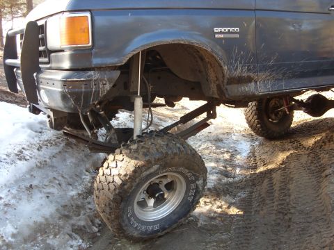 1988 Ford Bronco - Front suspension and fender of a 1988 Ford Bronco, showing off-road modifications.