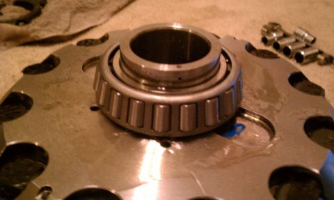 1990 Ford Bronco - A differential bearing sits on a metal plate, with a set of sockets visible in the background. The registry claims this is a 1990 Ford Bron…