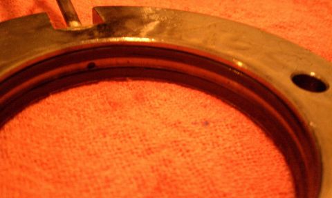 1990 Ford Bronco - A metal component, possibly a bearing or seal, is shown in detail against an orange textured background. The registry information may be in…