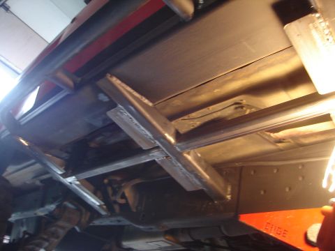 1989 Ford Bronco - Custom metalwork is visible on the underbody of a vehicle, with a red object labeled "ERIDE" in the foreground.