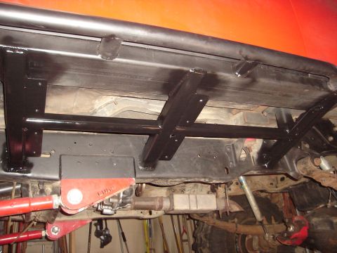 1989 Ford Bronco - The undercarriage shows aftermarket modifications including a roll bar and suspension components.