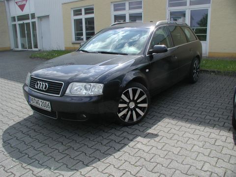 2003 Audi A6 - A black Audi wagon is parked outside a building with a red triangular sign above the entrance.