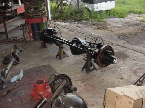 1992 Ford Bronco - Workshop scene with a vehicle axle assembly and other parts on the floor.