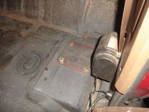 1989 Ford Bronco - Close-up of the interior floor showing a metal plate and seatbelt mechanism.