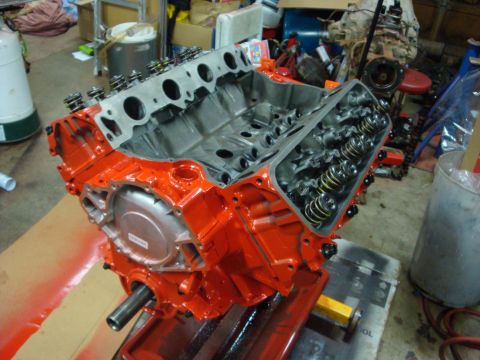 1989 Ford Bronco - A freshly painted orange V8 engine block sits on a stand, ready for assembly.