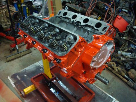 1989 Ford Bronco - V8 engine block painted orange, undergoing rebuild or assembly on an engine stand.