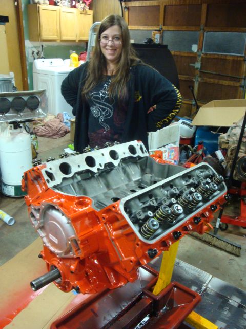 1989 Ford Bronco - Engine block on a stand, ready for rebuild. Garage interior with woman in background.