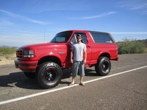 1996 Ford Bronco - Man poses with his red 1996 Ford Bronco on a sunny day.