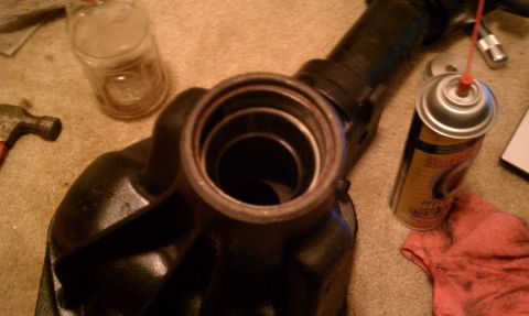 1990 Ford Bronco - Differential housing part, likely for a truck or SUV, with tools and lubricant present.
