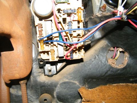 1982 Ford Bronco - Interior view of a vehicle's fuse box and wiring harness, showing multiple fuses and connectors.