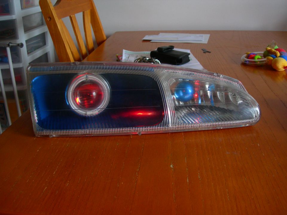 Aftermarket headlight assembly with projector lens and red/blue LEDs