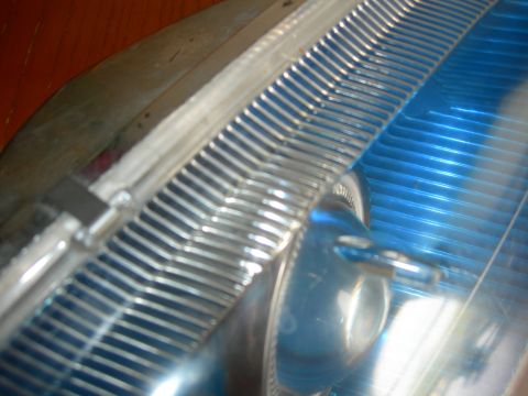 1984 Ford Bronco - A close-up view of a vehicle's headlight and grille section, showing intricate chrome detailing.