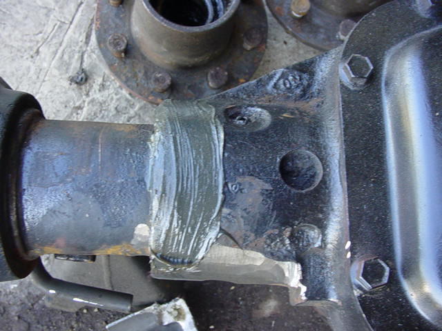 Fresh weld bead joining an axle tube to a cast differential housing with gusset plate