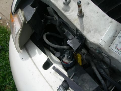 1984 Ford Bronco - Close-up view of the engine bay of a white vehicle, showing various components and wiring.