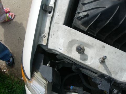 1984 Ford Bronco - Detail shot of a car's engine bay, showing components and the headlight assembly.