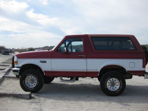 1995 Ford Bronco - This 1995 Ford Bronco is seen from the side, a two-tone red and white paint scheme and the distinctive "BRONCO" badging.