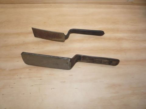 1969 Lincoln Continental - Two metal scrapers with angled blades and black handles are shown resting on a wooden surface.