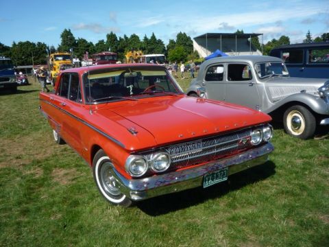 1969 Lincoln Continental - A vintage Mercury Monterey is displayed at an outdoor event with other vehicles in the background.