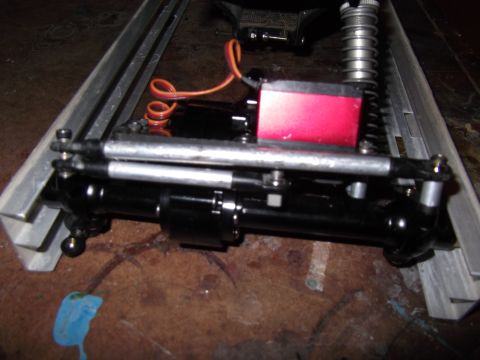 1989 Ford Bronco - Close-up of an RC car's chassis, showing the steering servo and suspension parts.