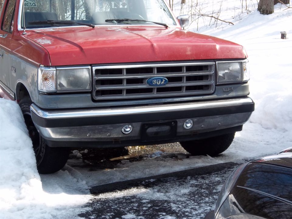 1989 Ford F-150 front grille and headlights with snow on the ground