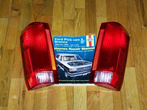 1989 Ford Bronco - A Haynes repair manual for Ford Pick-ups & Bronco is displayed with two vehicle taillights.