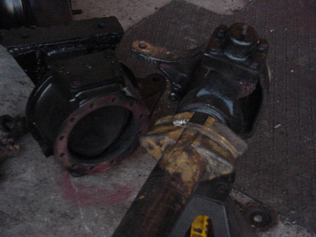 Black painted vehicle axle differential housing and driveshaft with yellow markings