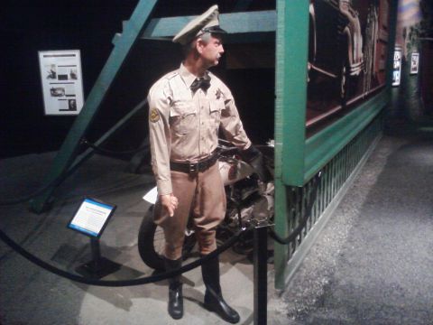 1995 Ford Taurus - A museum display features a mannequin dressed as a police officer, posed with a motorcycle.