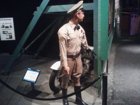 1995 Ford Taurus - A museum display features a mannequin in a vintage police uniform positioned beside a motorcycle.