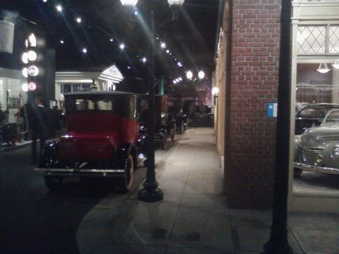 1995 Ford Taurus - Several antique vehicles are displayed in a museum setting, resembling a street scene.