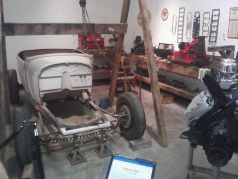 1995 Ford Taurus - A vintage car body is suspended by a hoist, with its chassis supported by jack stands in a workshop setting.