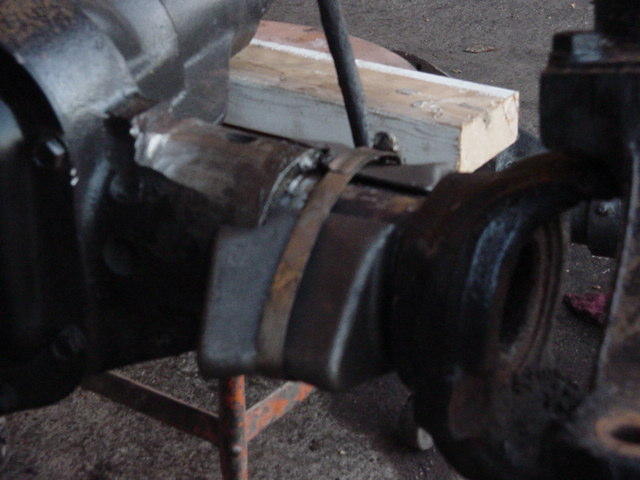 Close-up of a vehicle's axle assembly with metal brackets and a strap