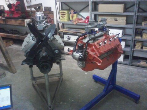 1995 Ford Taurus - Two engines are displayed on stands in a museum setting with shelves in the background.