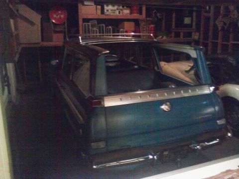 1995 Ford Taurus - Station wagon with chrome accents and roof rack sits in a dimly lit garage.