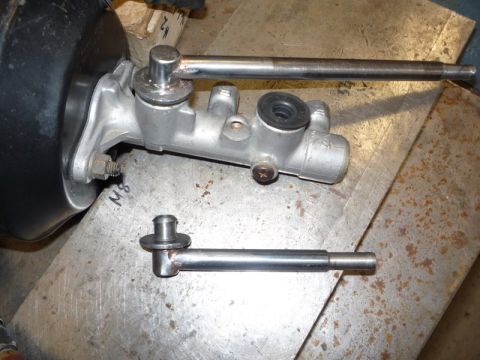 1969 MINI Cooper - Brake master cylinder and associated pushrod components are shown on a metal workbench.