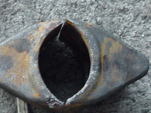 1992 Ford Bronco - This heavily rusted metal component features a distinct split opening, suggesting it is a part from a larger assembly.