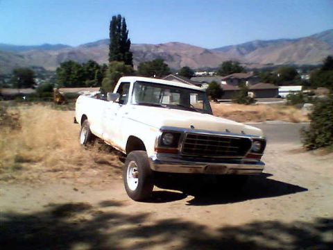 1988 Ford Bronco - This 1979 Ford F-150 pickup truck is parked on a dirt road with a mountainous landscape behind it.