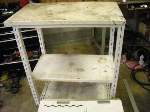 1979 Ford F-150 - A utilitarian workbench sits in a cluttered garage, surrounded by tools and electrical cords.