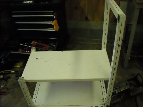 1979 Ford F-150 - A white metal shelving unit with two shelves is shown in a garage setting next to a toolbox.