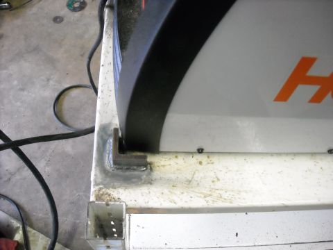 1979 Ford F-150 - A metal bracket is welded to a white surface, supporting a portion of a machine.