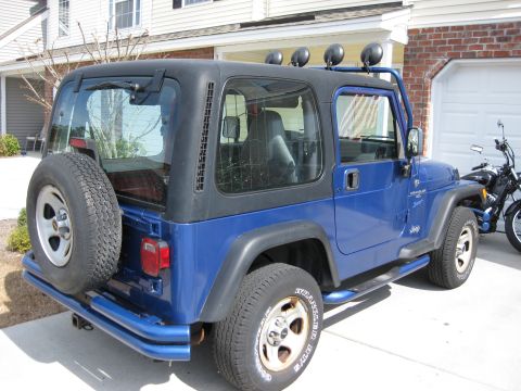 1998 Jeep Wrangler - This blue 1998 Jeep Wrangler features a black hardtop and a spare tire mounted on the rear.