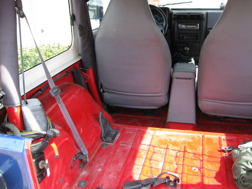 Jeep interior with red floor, grey seats, and dashboard visible. A Supermotors logo is in the lower right
