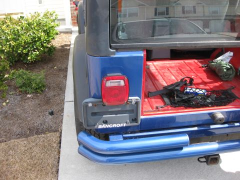1998 Jeep Wrangler - Rear view of a blue 1998 Jeep Wrangler, showing the open trunk and custom blue rear bumper.