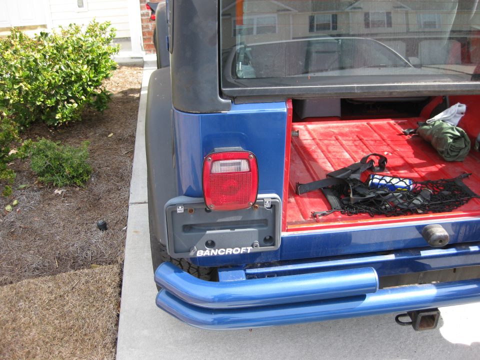 Blue 1998 Jeep Wrangler rear view with open trunk and blue bumper